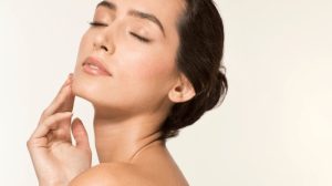 ქალი იცავს კანს მზისგან SPF კრემით სანაპიროზე