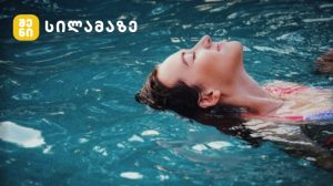 ქალი აუზში ცურავს და ზრუნავს კანის ჯანმრთელობაზე